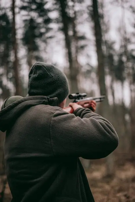 man aiming air rifle